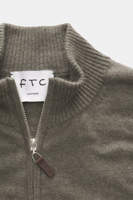 Nahaufnahme der FTC Cashmere Strickjacke graugrün von oben, zeigt gerippten Stehkragen, feines Strickbild, verdeckten Zwei-Wege-Reißverschluss mit Leder-Logo.