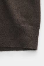 Nahaufnahme der FTC Cashmere Strickjacke dunkelbraun im Detail, von oben fotografiert, zeigt feines Strickbild und gerippte Bündchen.
