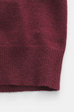 Nahaufnahme der FTC Cashmere Strickjacke bordeaux, fotografiert von vorne unten, zeigt feines Strickbild, gerippten Stehkragen und weiche Fair-Trade-Cashmere-Qualität.