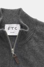 Nahaufnahme der FTC Cashmere Strickjacke dunkelgrau meliert von oben, mit geripptem Stehkragen, verdecktem Reißverschluss und Leder-Logo.