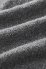 Nahaufnahme der fein gestrickten, dunkelgrau melierten FTC Cashmere Strickjacke, Fokus auf weichen Fair-Trade-Cashmere Stoff.