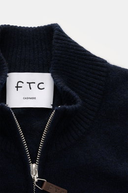 Close-up front view of FTC Cashmere cardigan navy showing ribbed standing collar, concealed two-way zip with leather logo detail, and fine knit texture.

Description: <p>Fair Trade cashmere, timeless design: This cardigan by FTC has been sustainably produ