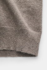 Nahaufnahme der FTC Cashmere Strickjacke taupe meliert, aufgenommen aus seitlicher Perspektive, zeigt feines Strickbild, weichen Griff und gerippten Saum.
