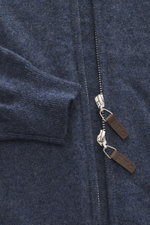 Nahaufnahme der FTC Cashmere Strickjacke graublau meliert von oben, zeigt feines Strickbild, verdeckten Zwei-Wege-Reißverschluss mit Leder-Logo, gerippten Stehkragen und flexible Rippbündchen aus nachhaltigem Fair-Trade-Cashmere.