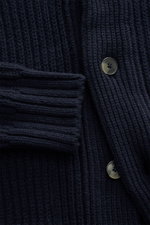 Nahaufnahme des Closed Cardigan navy von vorne, Patentstrick aus reiner Wolle, weicher Griff, grobes Strickbild, Regular Fit, Vier-Knopf-Leiste, Schalkragen, aufgesetzte Hüfttaschen, breite Rippbündchen.