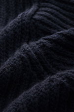 Nahaufnahme des groben, schweren Patentstricks aus reiner Wolle des Closed Cardigan navy mit weichem Griff, Schalkragen, Vier-Knopf-Leiste, Regular Fit, aufgesetzten Hüfttaschen und breiten Rippbündchen, Detailansicht der Textur.