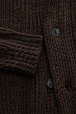 Nahaufnahme des groben, schweren Strickbilds des Closed Cardigan dunkelbraun aus Patentstrick, vier Knöpfe, Schalkragen, Hüfttaschen, Rippbündchen, Regular Fit, weicher Griff.