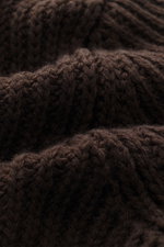 Nahaufnahme des groben, schweren Patentstricks vom Closed Cardigan dunkelbraun, Detail von weichem Griff, Rippbündchen, Schalkragen.