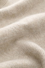 Close-up image of the 04651/ A trip in a bag Cardigan beige/sand patterned fabric showing rib knit made of wool and cashmere with a soft feel, medium-fine knit texture, and subtle Norwegian pattern, photographed from a front angle.