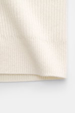 Close-up side view of the off-white von Braun Cashmere Cardigan showing soft pure cashmere ribbed knit, elastic cuffs, and fine texture.