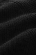 Close-up front view of the von Braun Cashmere Cardigan black showing soft pure cashmere ribbed knit texture with slim fit, high collar, raglan sleeves, two-way zipper, and elastic cuffs, a basic for the cold season with soft touch and classic style.