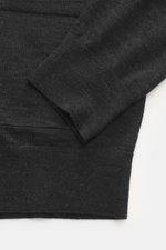 Nahaufnahme des von Braun Merino Feinstrick-Cardigan anthrazit, perspektivisch auf Ärmel und aufgesetzte Hüfttasche mit feinem Slim-Fit Strick.