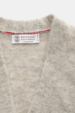 Brunello Cucinelli Cardigan hellgrau/sand meliert von oben fotografiert, weicher Alpaka-Mix mit Wappenknöpfen, V-Ausschnitt, Kontrastkante.