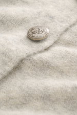Brunello Cucinelli Cardigan hellgrau/sand meliert, Detailaufnahme von oben, weicher Alpaka-Mix mit Wappenknopf und feiner Strickstruktur.