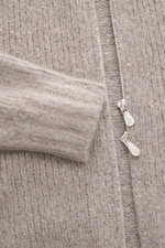 Nahaufnahme aus schräger Perspektive der taupe melierten Brunello Cucinelli Strickjacke mit grobem Strick, zwei-Wege-Reißverschluss und Rippbündchen.