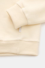 Close-up image from above of the sleeve and hem of the 04651/ A trip in a bag Rundhalspullover creme, showing its soft fleece texture and ribbed cuffs. <p>Legeres Layering Piece: Der Rundhalspullover von 04651/ A TRIP IN A BAG überzeugt mit seiner samtige
