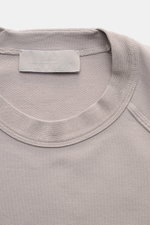 Close-up top view of Stone Island Sweatshirt 'Ghost Piece' grau showing round neckline, elastic cotton fabric, tonal compass badge on sleeve, raglan sleeves, and comfortable cuffs.

Description: <p>STONE ISLAND bietet mit diesem Sweatshirt aus elastischer