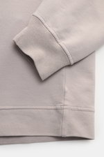 Close-up front view of Stone Island Sweatshirt 'Ghost Piece' grau showing soft, stretchy cotton fabric with tonal compass badge on sleeve cuff and comfortable ribbed cuffs and hem.

Description: <p>STONE ISLAND bietet mit diesem Sweatshirt aus elastischer