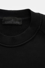Close-up front view of Stone Island Crew neck sweatshirt 'Ghost Piece' black, showing ribbed crew neck and textured cotton fabric.

<p>A timeless basic piece: This sporty sweatshirt from the 'Ghost' Capsule Collection by STONE ISLAND provides the perfect 