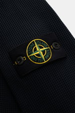 Close-up of the Stone Island Rundhalspullover 'Waffle' navy showing the compass badge on the upper arm, photographed from a side angle.

<p>Basic Piece mit Twist: Dieser Pullover im Waffelstrick von STONE ISLAND wird zur idealen Grundlage moderner Freizei