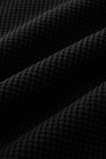 Close-up view of the black Stone Island Rundhalspullover 'Waffle' schwarz fabric showing its waffle knit texture in detail. Basic Piece mit Twist: Dieser Pullover im Waffelstrick von STONE ISLAND wird zur idealen Grundlage moderner Freizeitlooks und lässt
