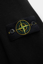 Close-up front angle of Stone Island Rundhalspullover 'Waffle' schwarz showing black waffle knit texture and compass badge on upper arm.

<p>Basic Piece mit Twist: Dieser Pullover im Waffelstrick von STONE ISLAND wird zur idealen Grundlage moderner Freize