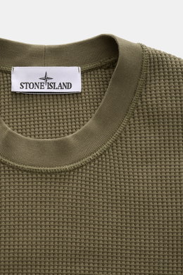 Stone Island Rundhalspullover 'Waffle' oliv shown from a close-up top front view, featuring waffle knit cotton fabric and ribbed crew neck. <p>Basic Piece mit Twist: Dieser Pullover im Waffelstrick von STONE ISLAND wird zur idealen Grundlage moderner Frei
