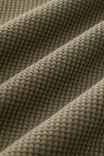 Close-up, angled view of the olive green Stone Island Rundhalspullover 'Waffle' showing detailed waffle knit texture. <p>Basic Piece mit Twist: Dieser Pullover im Waffelstrick von STONE ISLAND wird zur idealen Grundlage moderner Freizeitlooks und lässt si