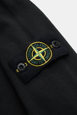 Close-up of the Stone Island Long sleeve black showing the compass badge on the sleeve, photographed from a top-down angle.

Description: <p>With this crew neck long sleeve in heavy cotton jersey with compass badge on the sleeve, STONE ISLAND brings us a 