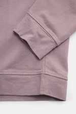 Nahaufnahme des Stone Island Longsleeve mauve von oben, zeigt Rundhalsausschnitt, Rippbündchen, Kompass-Badge, schwere Baumwolle, Regular Fit.