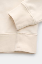 Nahaufnahme des Stone Island Rundhals-Sweatshirt 'Basic Sweat' creme von unten, zeigt weiche Baumwolle, Rippbündchen und Nahtdetails.