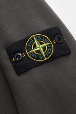 Stone Island Rundhals-Sweatshirt 'Basic Sweat' dunkelgrau, Detailansicht Kompass-Badge am Oberarm, reine Baumwolle, Regular Fit, Rippbündchen.