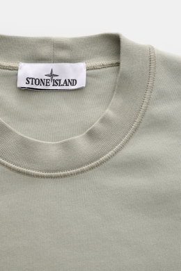 Close-up front view of Stone Island Rundhals-Sweatshirt 'Basic Sweat' salbei in sage green, showing the round neckline and brand label.

<p>Zeitloses Basic Piece: Das sportive Sweatshirt von STONE ISLAND wird zur idealen Grundlage legerer Freizeitlooks un