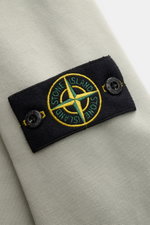 Close-up from a top angle of the Stone Island Rundhals-Sweatshirt "Basic Sweat" salbei showing the black compass badge on the sleeve.

<p>Zeitloses Basic Piece: Das sportive Sweatshirt von STONE ISLAND wird zur idealen Grundlage legerer Freizeitlooks und 