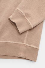 Stone Island Crew neck sweatshirt 'Washed Sweat' beige shown from a close-up perspective of the cuff and hem, featuring pure cotton fabric, soft feel, authentic washed effect, regular fit, crew neck with seam, compass badge on the upper sleeve, and comfor
