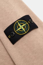 Close-up view of the compass badge on the sleeve of the Stone Island Crew neck sweatshirt 'Washed Sweat' beige, showcasing the fabric texture and badge details.

Description: <p>STONE ISLAND’s signature piece dyeing is used with a modern washed effect in 