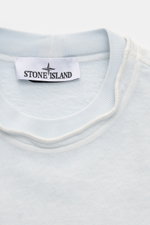 Close-up front view of Stone Island Crew neck sweatshirt 'Washed Sweat' pastel blue showing crew neck with seam and Stone Island label.

<p>STONE ISLAND’s signature piece dyeing is used with a modern washed effect in this sweatshirt and external seams on 