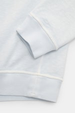 Close-up side view of Stone Island Crew neck sweatshirt 'Washed Sweat' pastel blue showing ribbed cuffs, hem, and seam details with authentic washed effect. 

Description: <p>STONE ISLAND’s signature piece dyeing is used with a modern washed effect in thi