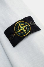 Close-up front angle of Stone Island Crew neck sweatshirt 'Washed Sweat' pastel blue showing compass badge on upper sleeve with washed effect and seam.

Description: <p>STONE ISLAND’s signature piece dyeing is used with a modern washed effect in this swea