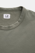 Close-up front top view of a C.P. Company Sweatshirt salbei in a slim fit, garment-dyed light olive green cotton with a round neckline and visible white label, showcasing soft fabric texture and neat stitching. <article class="text-token-text-primary w-fu
