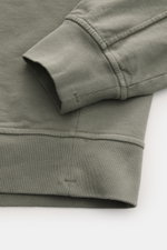 Close-up front view of C.P. Company Sweatshirt salbei showing the ribbed cuff and hem in soft, garment-dyed pure cotton with slim fit and lens detail. <article class="text-token-text-primary w-full focus:outline-none [--shadow-height:45px] has-data-writin