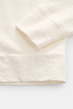 Nahaufnahme des C.P. Company Rundhals-Sweatshirt creme, seitliche Perspektive auf Ärmel und Saum mit Nahtdetails und Rippbündchen.