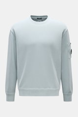 C.P. Company Sweatshirt rauchblau, frontale Ansicht, Rundhalsausschnitt, Oberarmtasche mit Linsen-Detail, reine Baumwolle, Regular Fit.