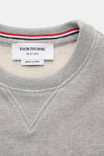 Nahaufnahme des Thom Browne Rundhals-Sweatshirts grau meliert, Perspektive auf Rundhalsausschnitt mit Grosgrain-Schlaufe, weichem Baumwollstoff, Rippbündchen und Kontraststreifen am Ärmel, Regular Fit, sportlich und casual.
