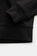 Nahaufnahme des schwarzen C.P. Company Sweatshirts, Perspektive auf Ärmel und Bund mit flexiblen Rippbündchen, aus reiner Baumwolle.