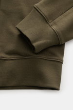 Nahaufnahme des C.P. Company Sweatshirts oliv, perspektivisch auf Ärmel und Bund mit weichem Griff, Rundhalsausschnitt, flexiblem Rippbündchen.
