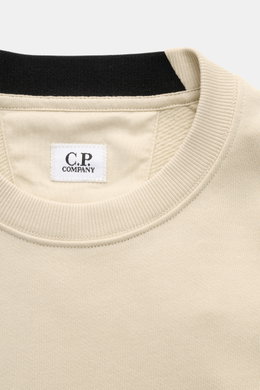 Nahaufnahme des Rundhalsausschnitts und des C.P. Company Sweatshirt sand, fotografiert aus frontaler Perspektive, aus reiner Baumwolle mit feinem Rippbündchen.
