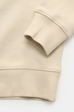 Nahaufnahme des C.P. Company Sweatshirt sand, Perspektive auf Ärmelbündchen und Saum aus reiner Baumwolle mit feiner Struktur.