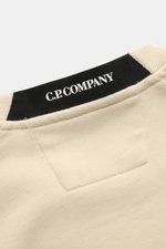 Nahaufnahme des Halsbereichs vom C.P. Company Sweatshirt sand, fotografiert von oben, mit schwarzem Markenlabel und sandfarbenem Baumwollstoff.