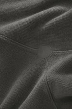 Nahaufnahme der Stoffstruktur und Nahtdetails des Stone Island Fleece-Kapuzenpullover 'Stellina' dunkelgrau, Fleece aus hochwertiger Microfaser und Schurwolle, weicher Griff, Regular Fit, dezentes Stellina-Stitching, praktische Kapuze, markante Naht mit r